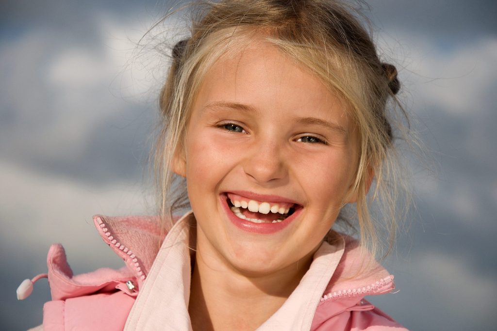 Happy smiling young girl in park