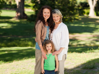 Smiling,Family,Looking,At,The,Camera,In,The,Park