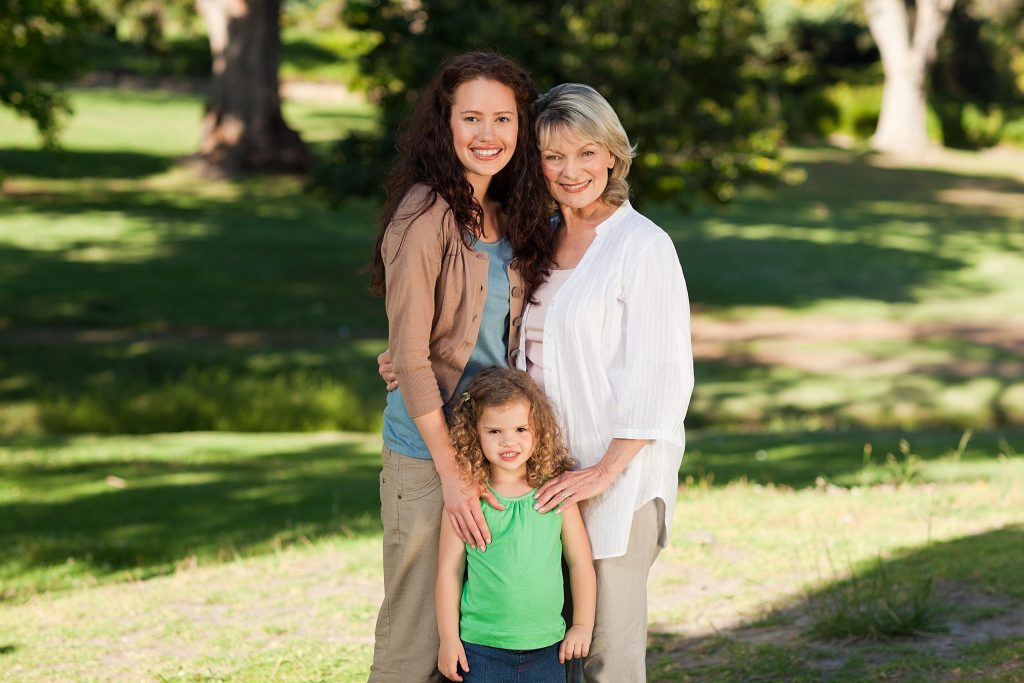 Smiling,Family,Looking,At,The,Camera,In,The,Park